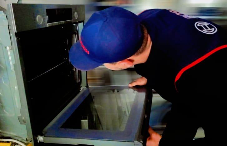 Technicien agréé Bosch réparant un four encastré à domicile
